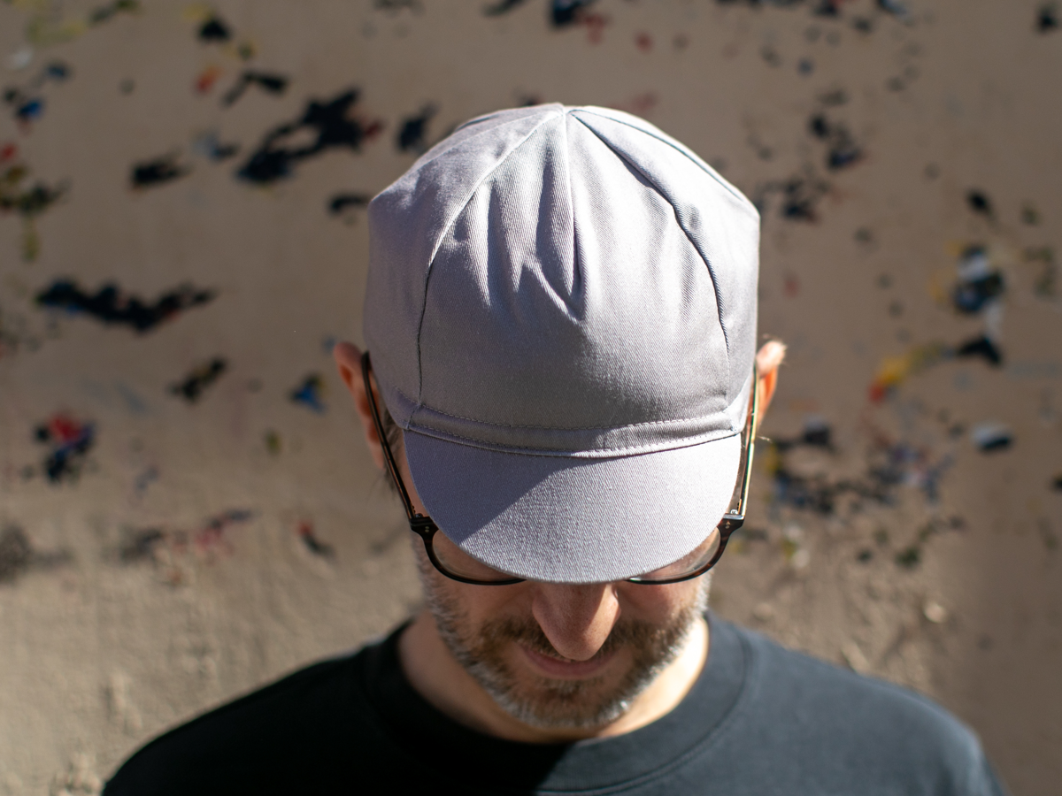 Blue Lug Muji Cycle Cap in grey, seen from above with brim down. Plain, unprinted panels with no graphics.