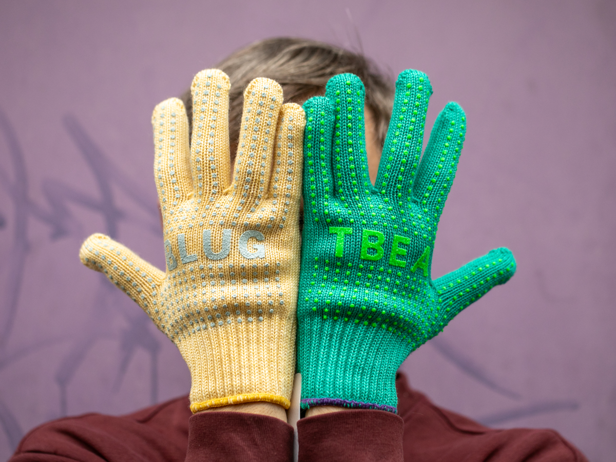 Blue Lug x Tembea merino wool gloves in yellow and teal, showing anti-slip dot pattern and BLUG/TBEA branding