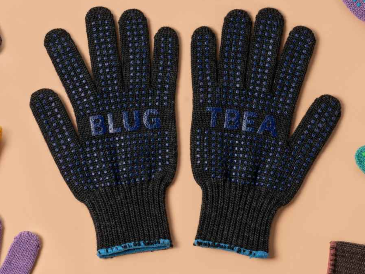 Blue Lug x Tembea merino wool gloves in black with blue anti-slip dots, flat lay showing both palms