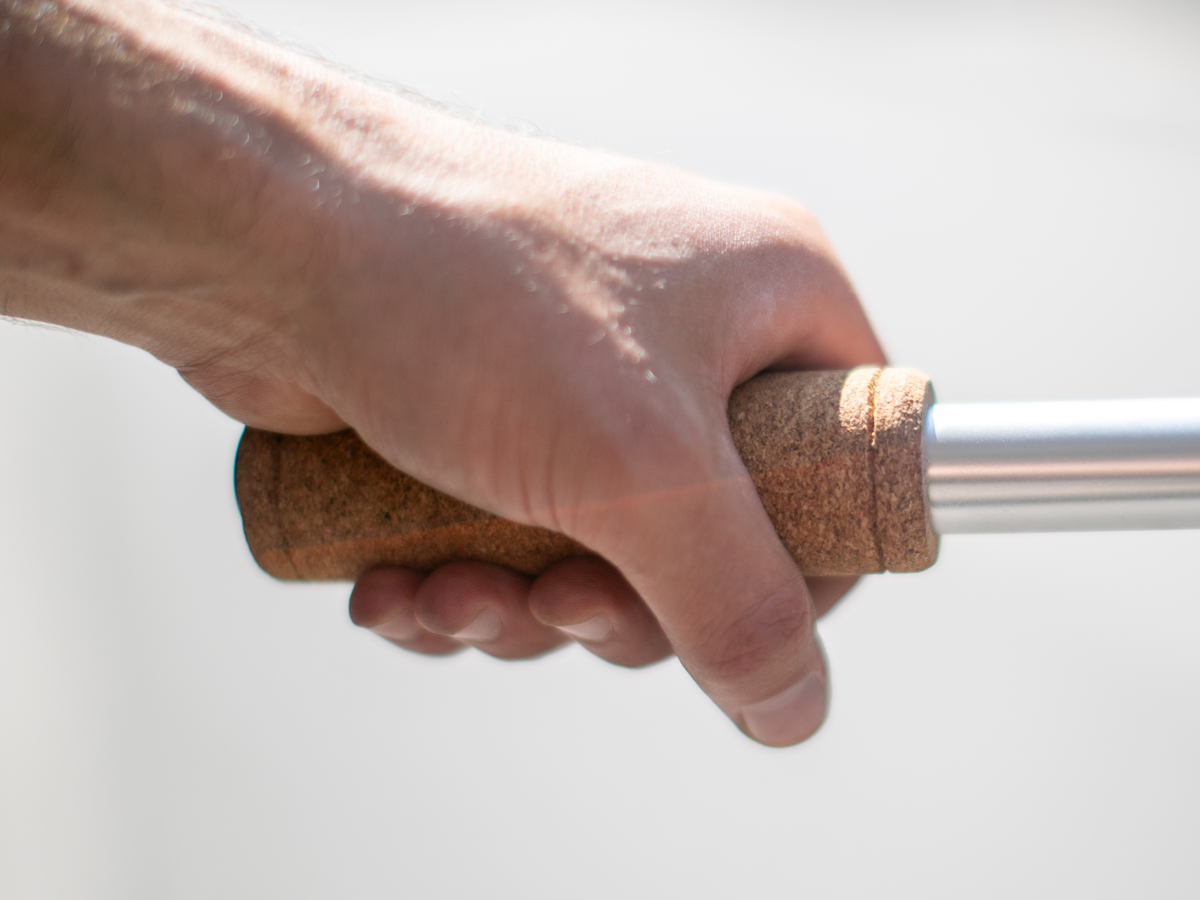 La Mad 1919 Cork Grip held in a hand — showing the grip diameter and natural cork texture in use, white background