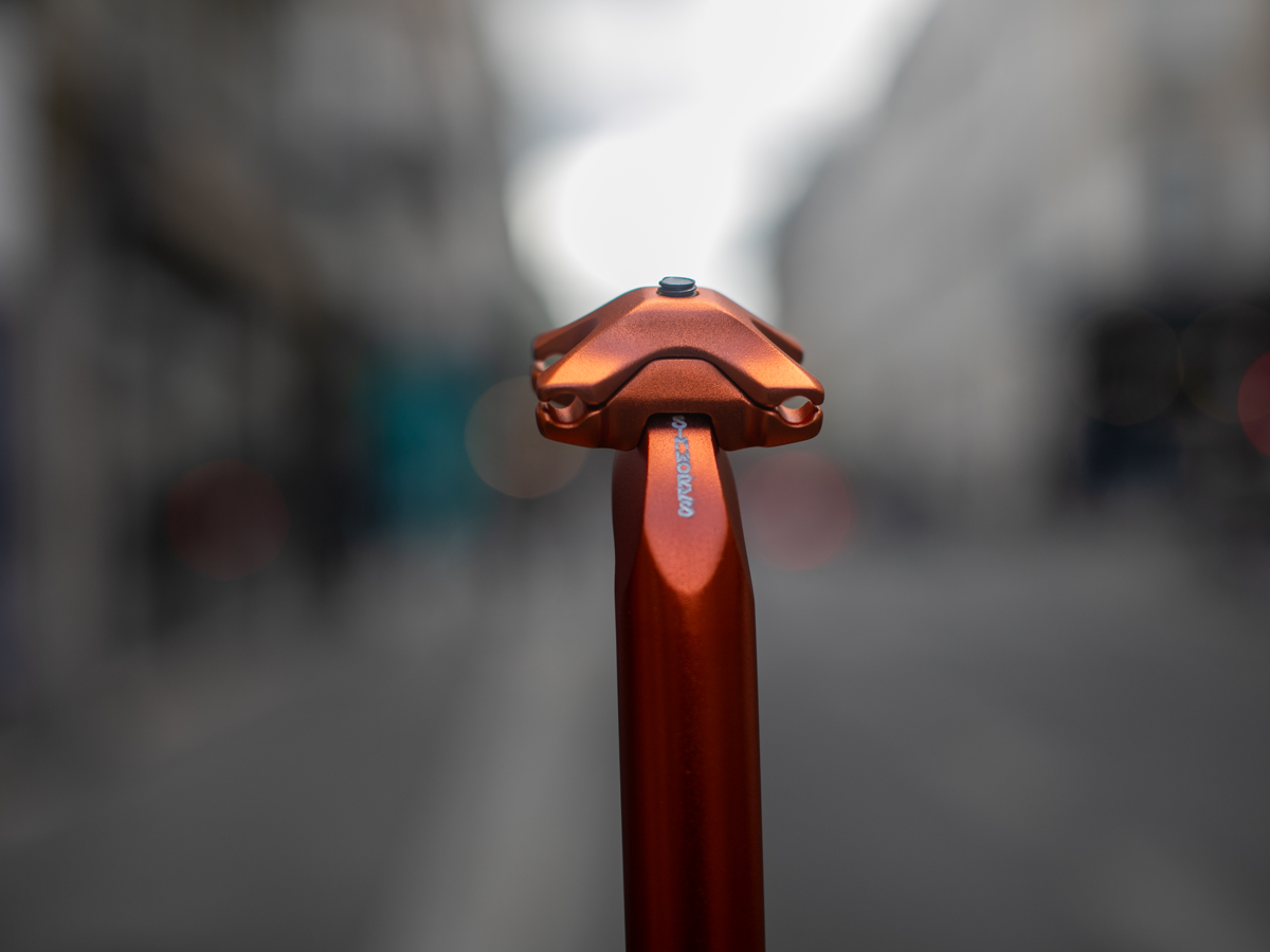 Tige de selle SimWorks Beatnik Sunrise — gros plan sur la tête de serrage Sunrise orange avec le logo SimWorks gravé à la main sur la tige