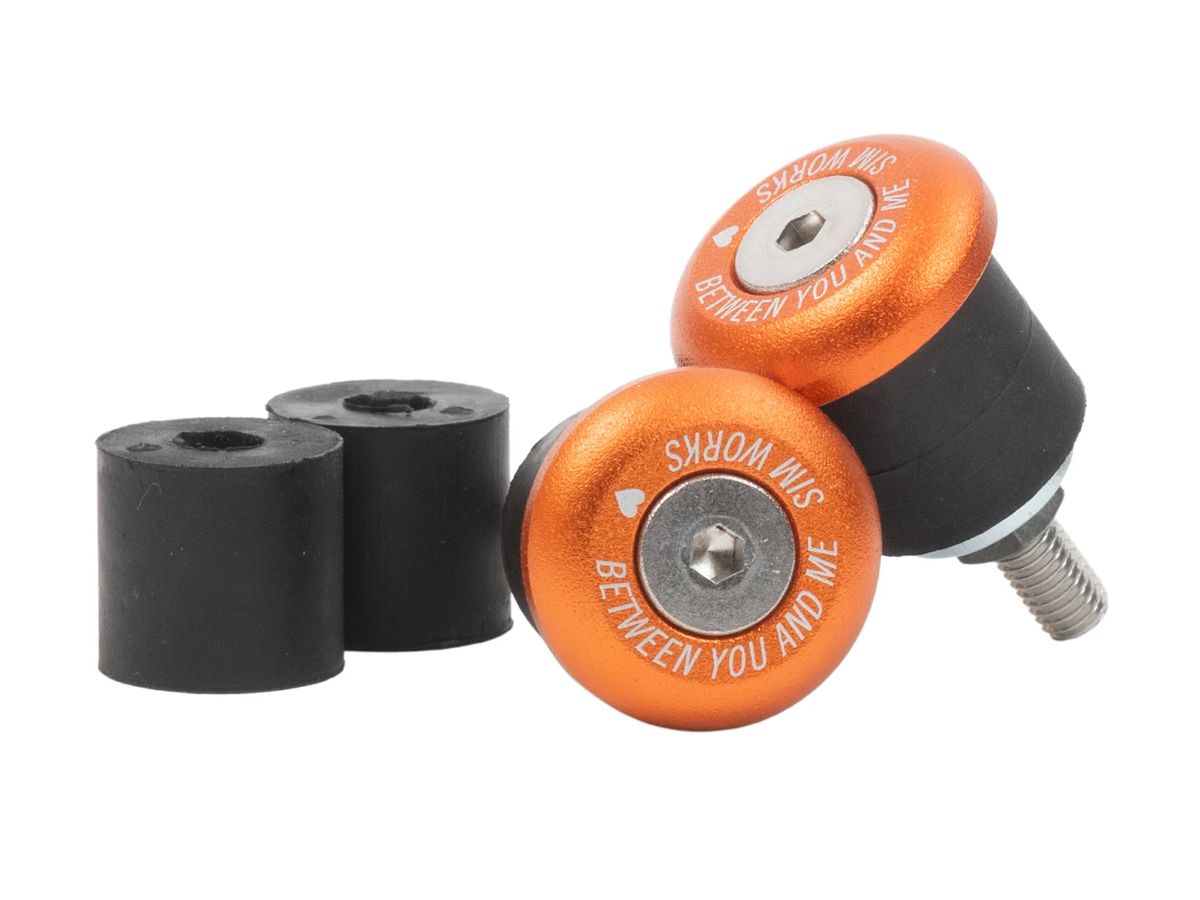 SimWorks Sim Drops 22 Bar Ends in Sunrise orange with black rubber expanders and stainless bolts — for 22mm flat handlebars, "Between You and Me / Sim Works" engraved on the face