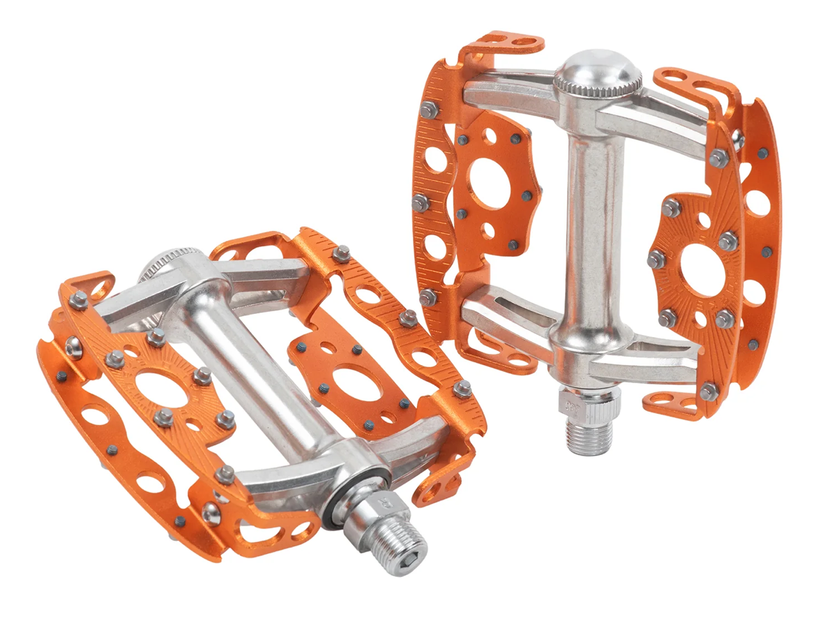 Pédales SimWorks Taco coloris Sunrise orange — paire sur fond blanc, montrant la grande plateforme en cage ouverte, les picots remplaçables et l'axe argenté à cônes et cuvettes